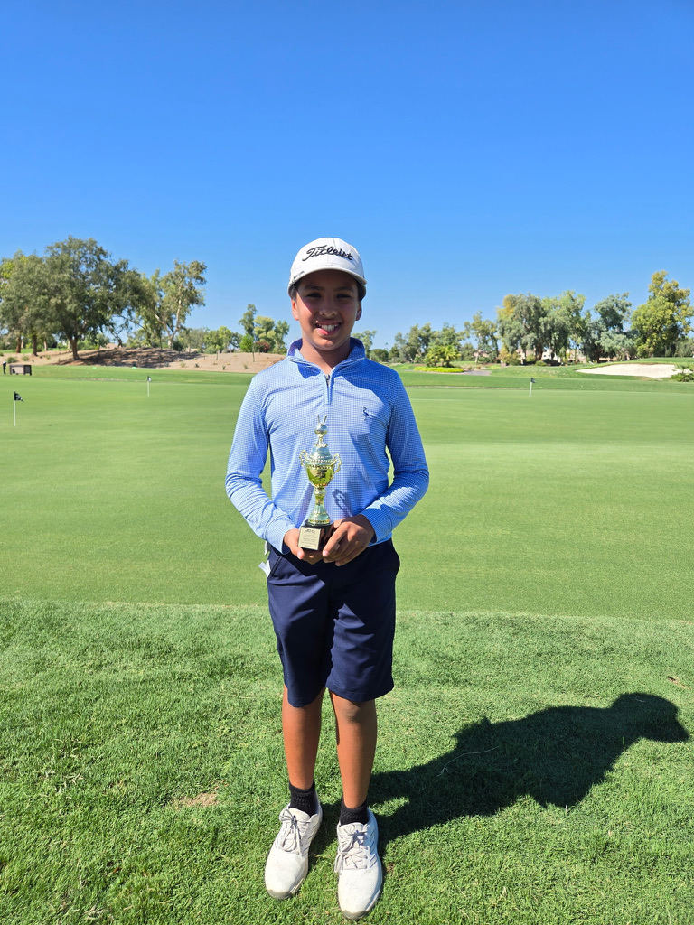 Junior golfer with a tournament trophy