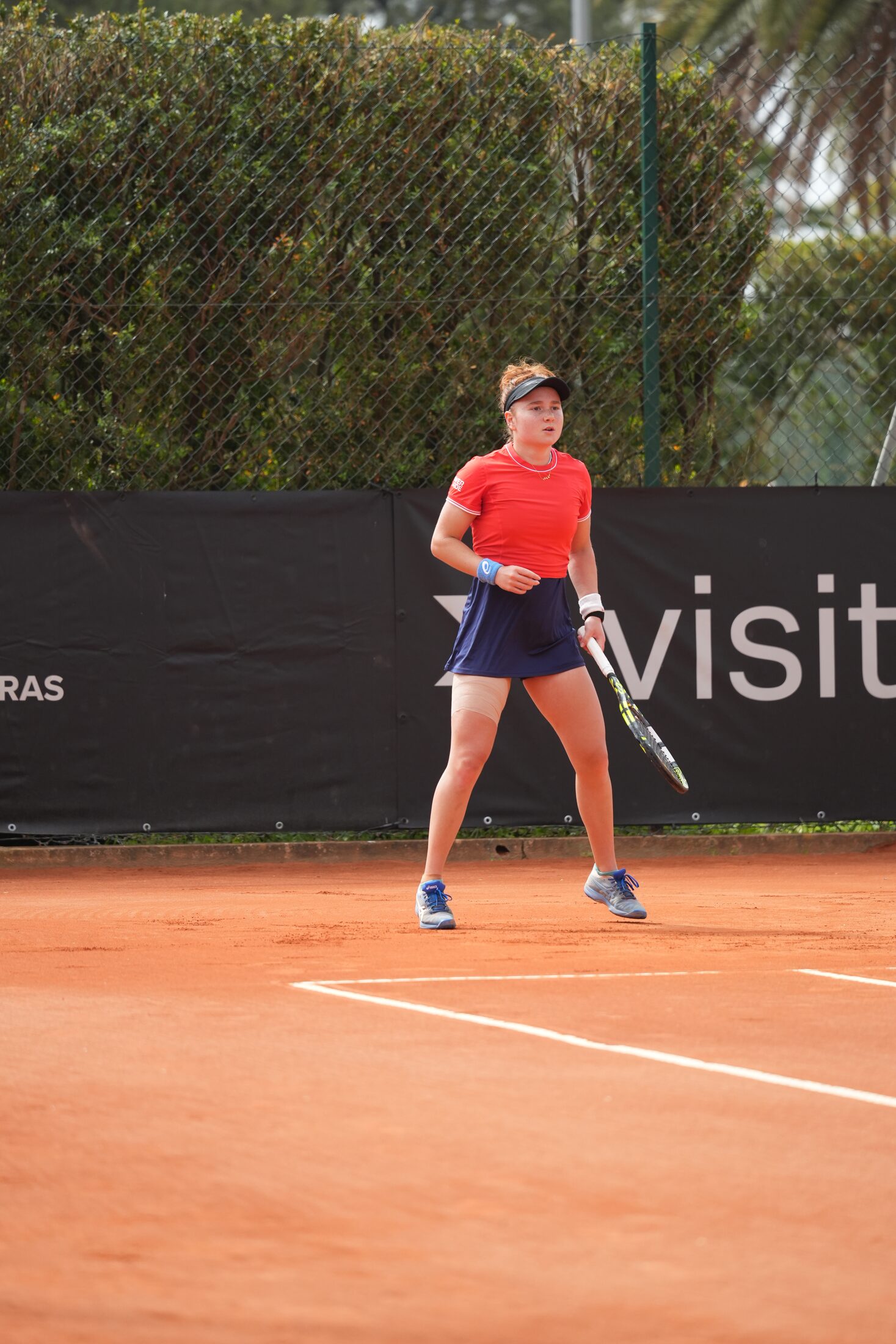 Tier 1 tennis athlete competing on red clay
