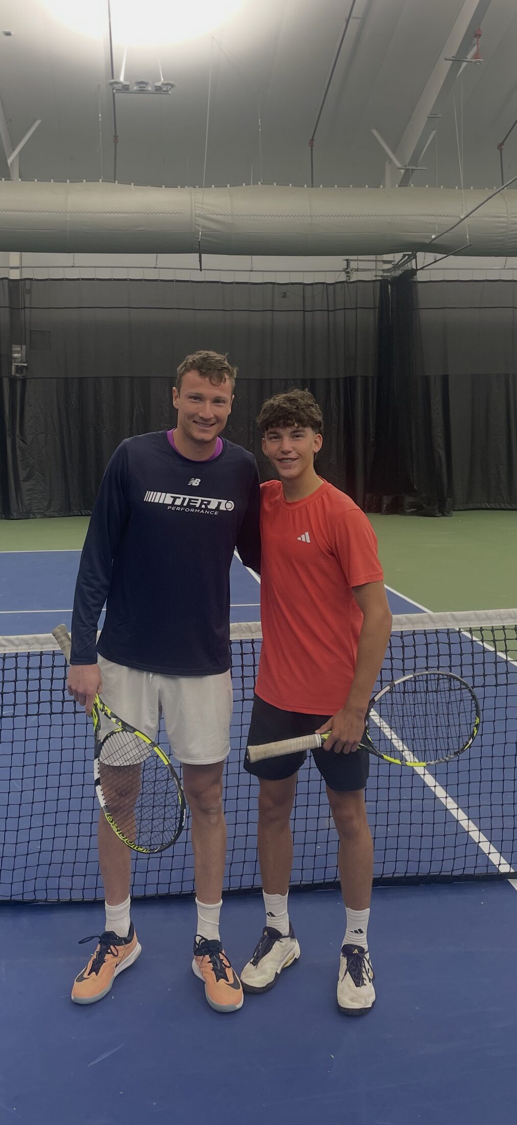 Tier 1 athlete training indoors with a visiting player