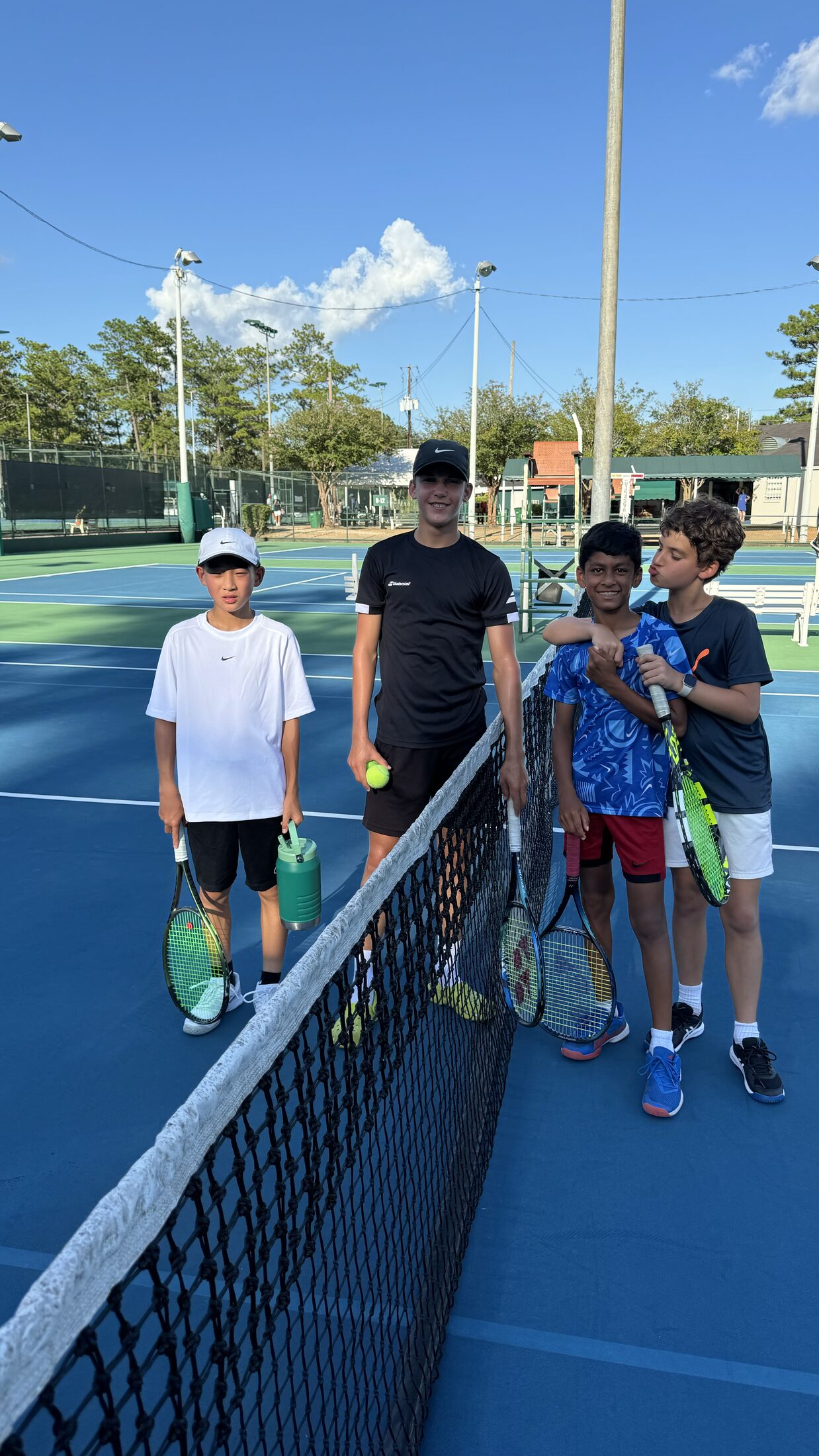 Tier 1 junior tennis athletes gathered at the net