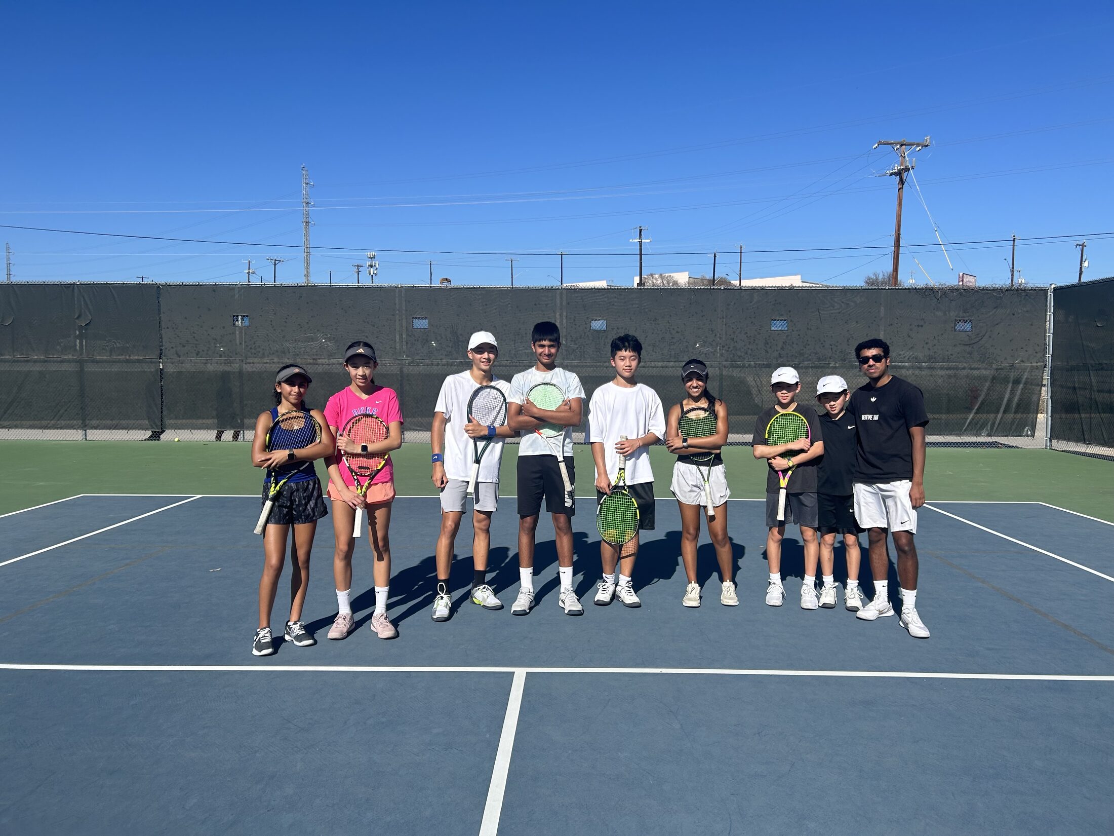 Tier 1 junior tennis athletes lined up on an outdoor court