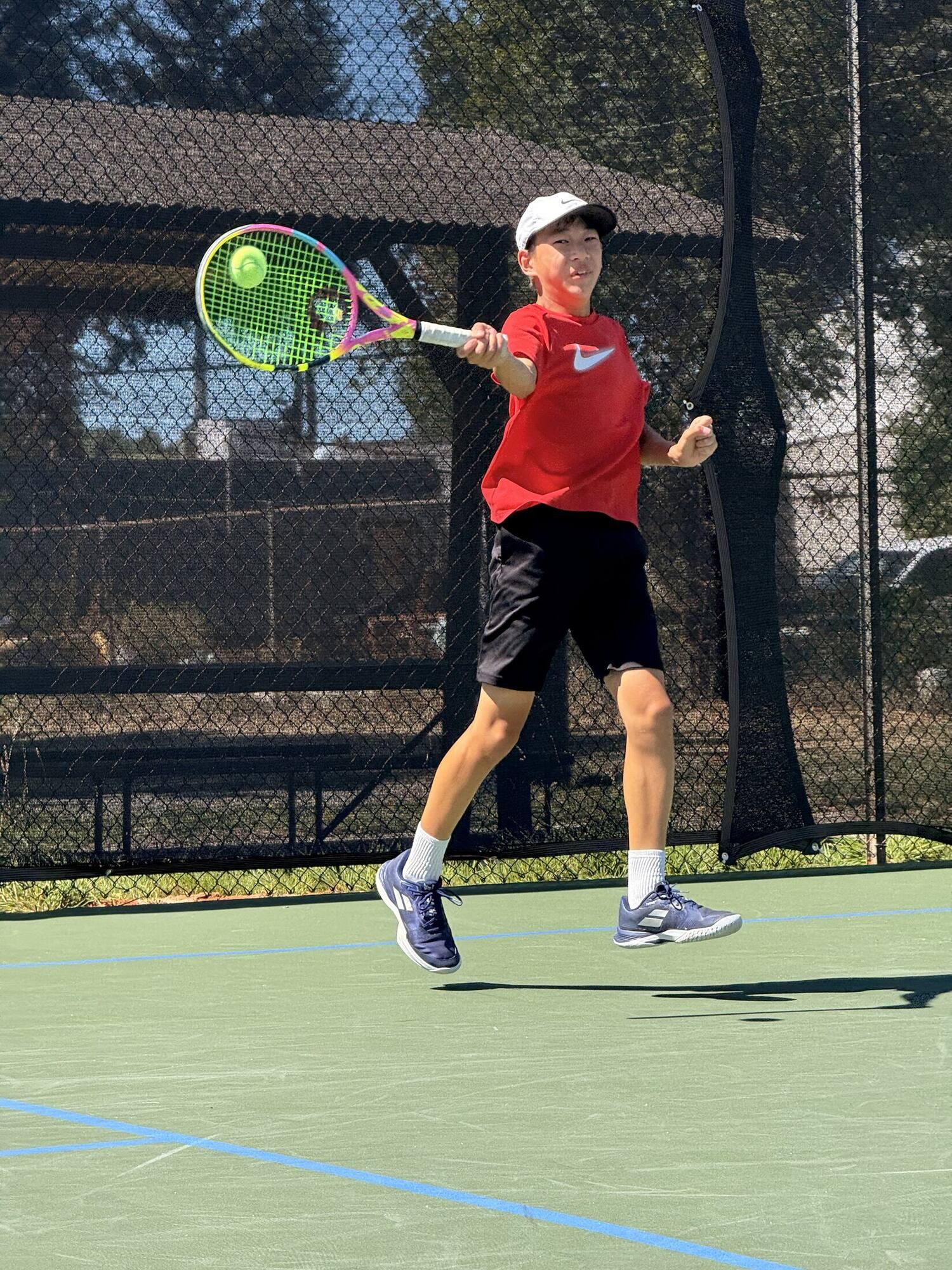 Tier 1 junior tennis player hitting an outdoor forehand