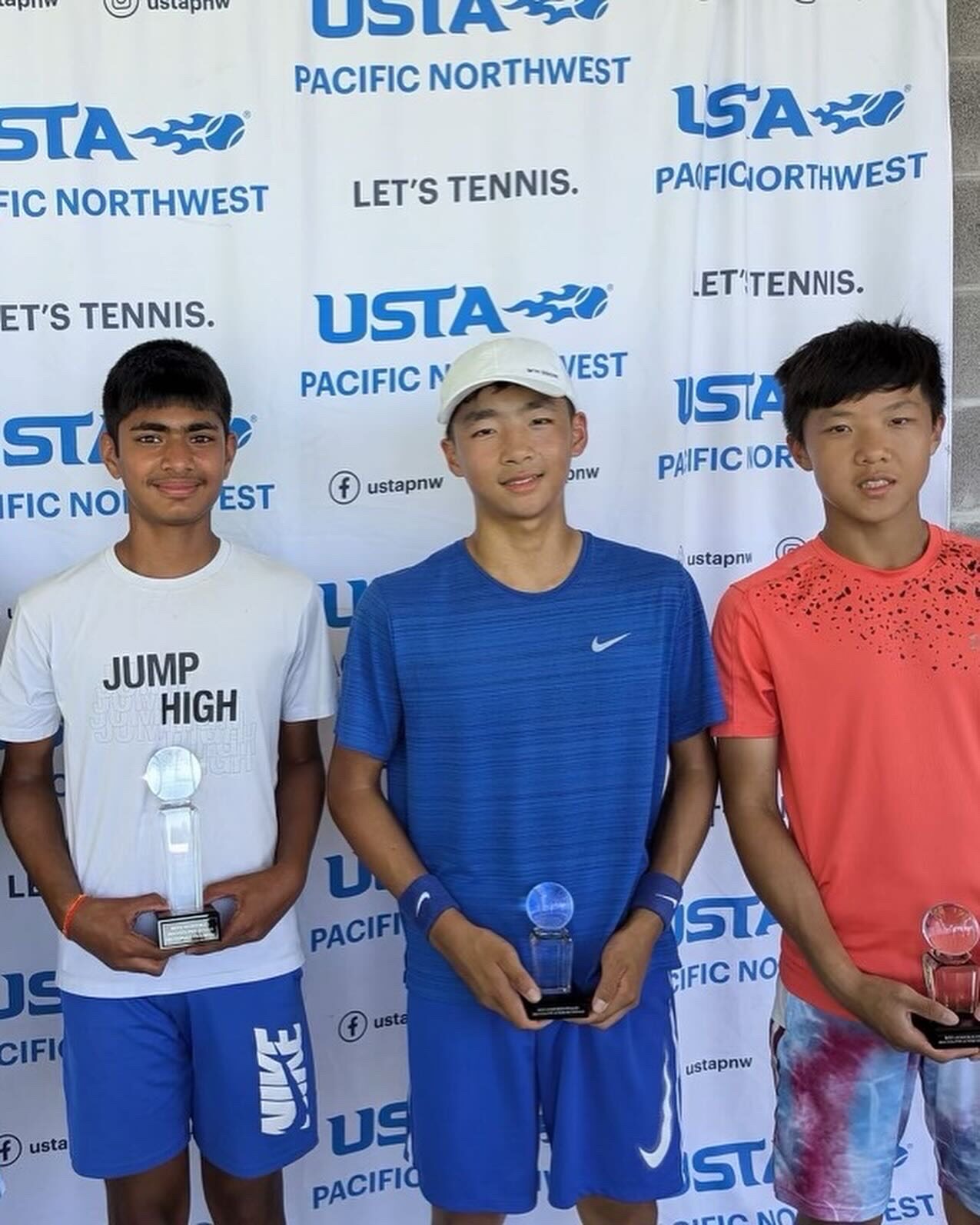 Tier 1 junior tennis finalists holding trophies at a USTA event